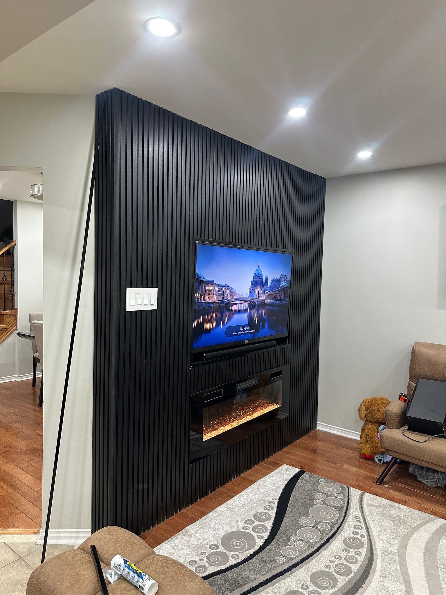 Dark media wall renovation with custom built-in shelving